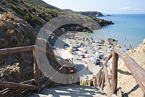 Masua beach in Sardinia island, crowd in summer sunny day. Focus