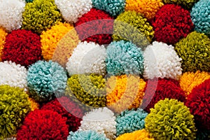 Mat of pompons made from multi-colored handmade yarn