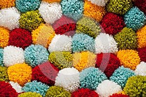 Mat of pompons made from multi-colored handmade yarn