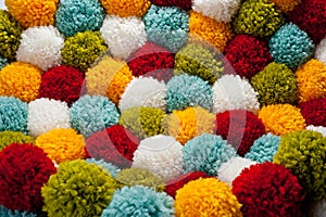 Mat of pompons made from multi-colored handmade yarn