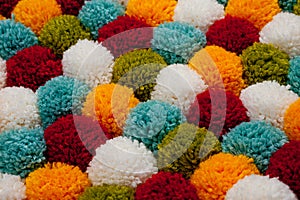 Mat of pompons made from multi-colored handmade yarn