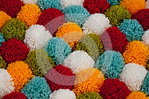 Mat of pompons made from multi-colored handmade yarn