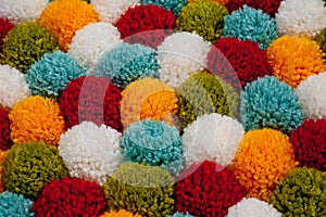 Mat of pompons made from multi-colored handmade yarn