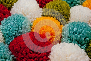 Mat of pompons made from multi-colored handmade yarn