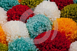 Mat of pompons made from multi-colored handmade yarn