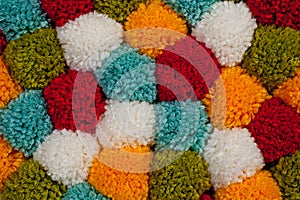 Mat of pompons made from multi-colored handmade yarn