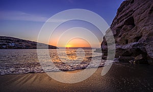 Matala beach at sunset with caves on the rocks, Crete, Greece