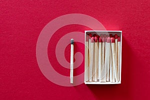 Match box package with new matches and one out burned. Red Background isolation  quarantine during coronavirus COVID-19 pandemic.