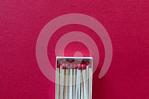 Match box package with new matches and one out burned. Red Background isolation  quarantine during coronavirus COVID-19 pandemic.