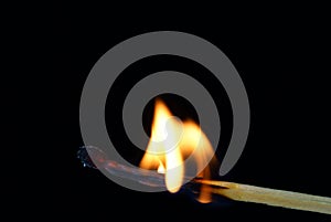 Match burning halfway, black background