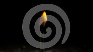 A match lights on a dark black background