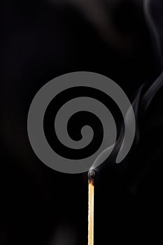 Match off on a black background with smoke