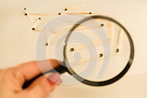 Match sticks with brown heads in row. Matches under magnifier, white background.