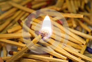 match sticks spread on white paper and match burning in center