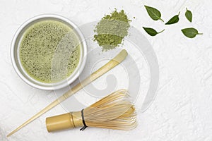 Matcha green tea in a bowl. Bamboo whisk and bamboo measuring spoon for making matcha green tea