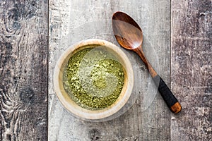 Matcha green tea in a bowl on wood