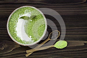 Matcha green tea chia seed pudding bowl, vegan dessert with raspberry and coconut milk. Overhead, top view, flat lay.