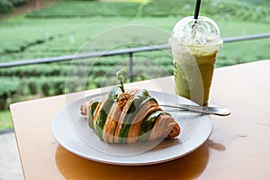 Matcha green tea with croissant on the wooden table at Choui Fong tea plantation