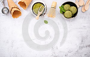 Matcha green tea ice cream with waffle cone and mint leaves  setup on white stone background . Summer and Sweet menu concept