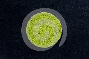 Matcha green tea powder on black slate background