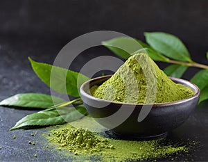 Matcha green tea powder in bowl, black table, green matcha leaves
