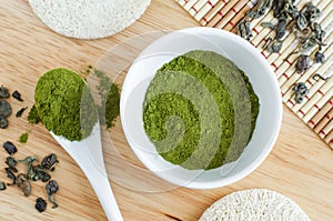 Matcha green tea powder in a white bowl, close up. Natural beauty treatment and spa. Homemade matcha mask recipe.