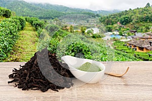 Matcha ,Green Tea on wood table and blurred tea plantation background