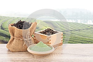 Matcha ,Green Tea on wood table and blurred tea plantation background