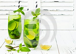 Matcha iced green tea with lime and fresh mint on white rustic background. Super food drink.