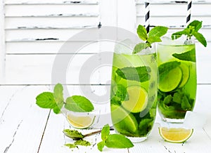 Matcha iced green tea with lime and fresh mint on white rustic background. Super food drink.