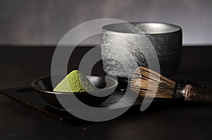 Matcha powder and green tea on dark background
