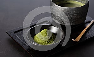 Matcha powder and green tea on dark background