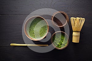 Matcha powder. Organic green matcha tea ceremony. Healthy drink. Traditional japanese drink on black wooden background
