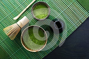 Matcha powder. Organic green matcha tea ceremony. Healthy drink. Traditional japanese drink on black wooden background