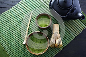 Matcha powder. Organic green matcha tea ceremony. Healthy drink. Traditional japanese drink on black wooden background