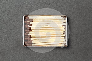 Matchbox full of matches over gray background