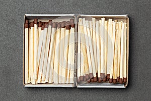 Matchboxes full of matches over gray background