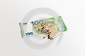 Matches are on 100 euro banknotes, made of wood, production of matchsticks, white background