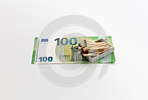 Matches in box are on 100 euro banknotes, made of wood, production of matchsticks, white background