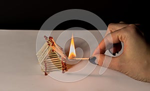 Matches house and hand with burning fire - risk of accident