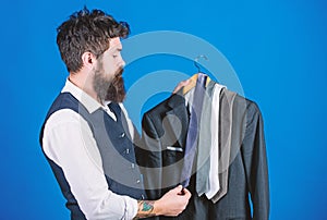 Matching necktie with outfit. Man bearded hipster hold neckties and formal suit. Guy choosing necktie. Perfect necktie