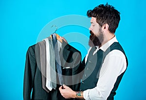 Matching necktie with outfit. Man bearded hipster hold neckties and formal suit. Guy choosing necktie. Perfect necktie