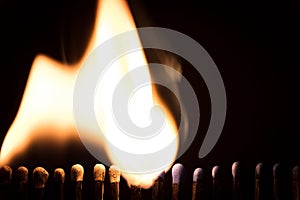 Matchsticks are burning in front of black, fire and flames