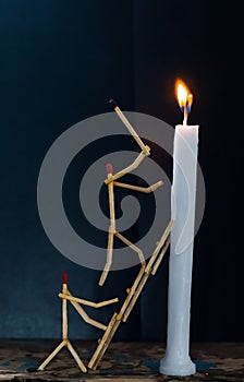 Matchsticks in form of a man lighting a candle, matchstick man lighting a candle.