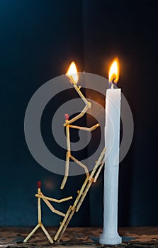 Matchsticks in form of a man lighting a candle, matchstick man lighting a candle.