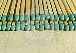 Matchsticks with green tips on a birch board macro close up