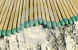 Matchsticks with green tips on a birch board macro close up