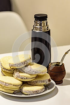 Mate and Delicious Argentinian and uruguayan cookies alfajores with cream on paper close-up on the table.