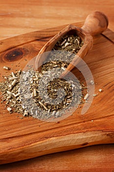 Mate with wooden scoop on wooden background