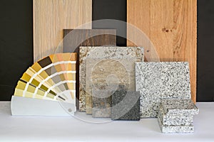 Material collage with natural stone, tiles, wooden parquet floor and color card for renovation of an apartment building